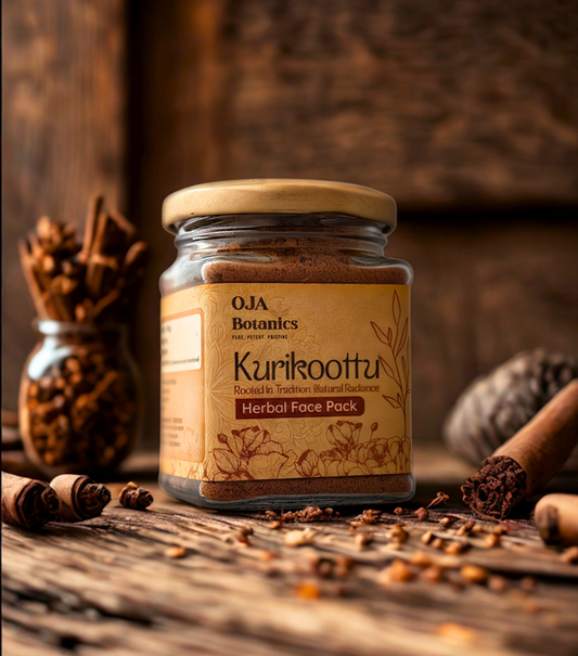 Jar of OJA Botanics Kurikoottu Herbal Face Pack on a wooden surface with herbs in the background