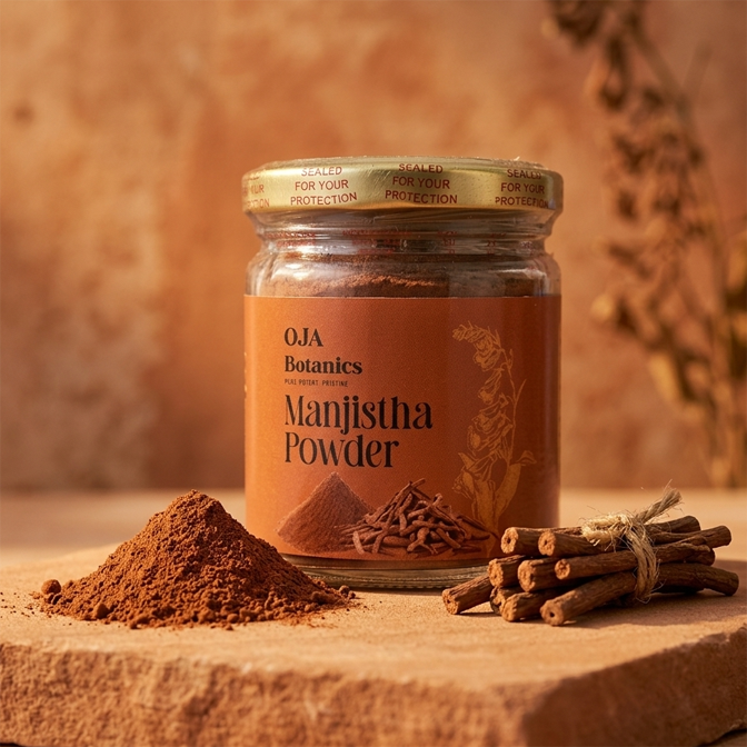Jar of OJA Botanics Manjistha Powder with cinnamon sticks and powder on a wooden surface